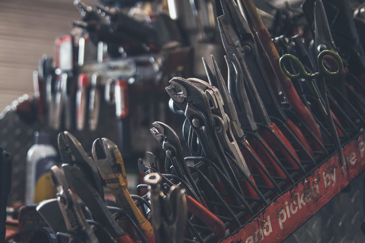 Rack of tradie tools including spanners, clamps, and pliers