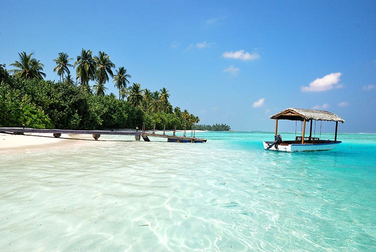 Beautiful beach view with a boat and a jetty