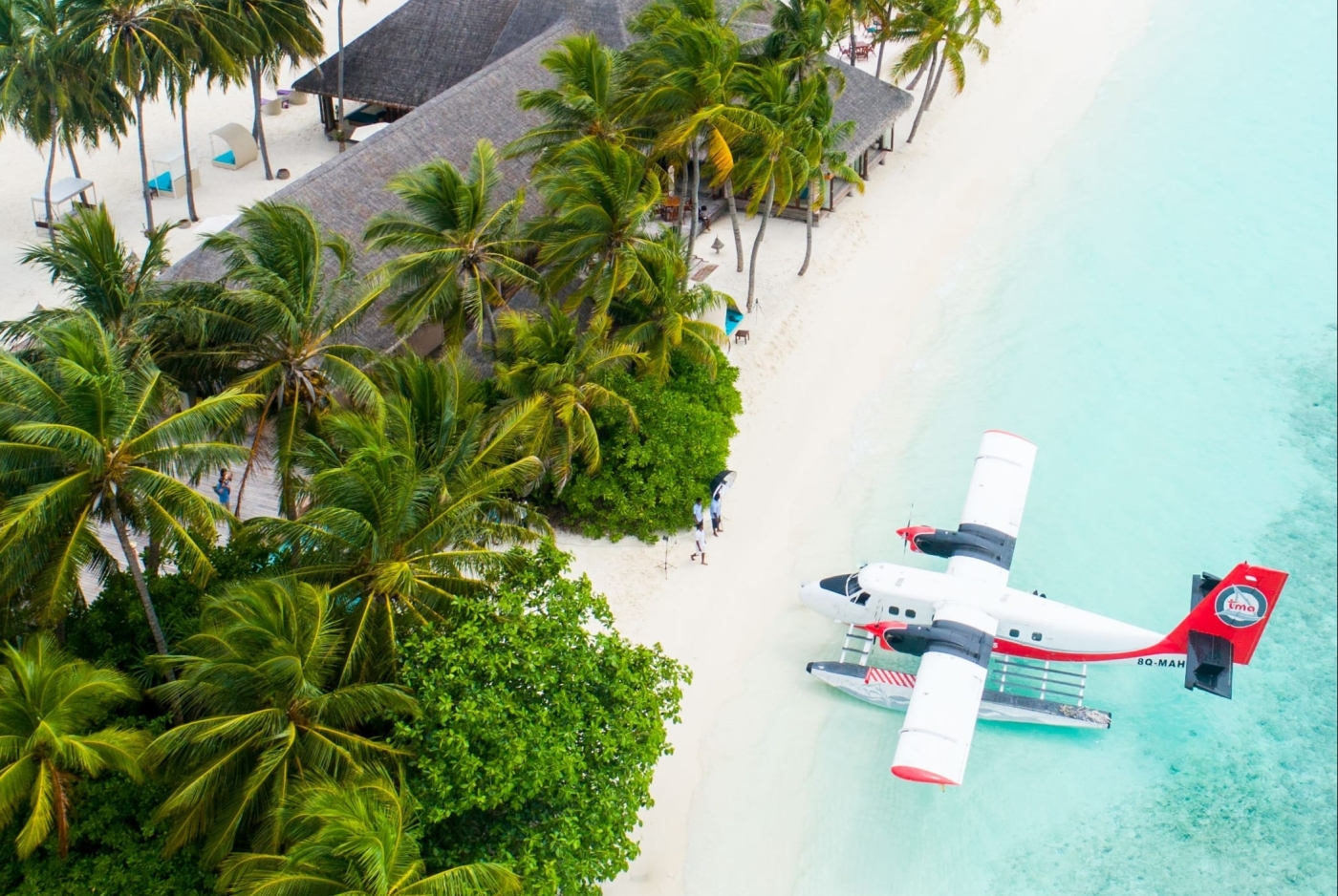 beautiful paradise scene with a sea plane on stunning blue water at a bright white beach